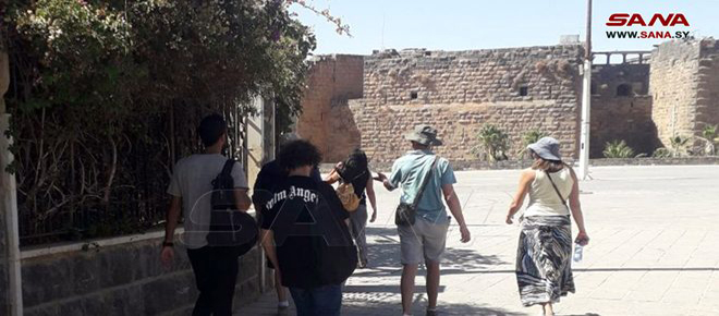 Turistas de varias nacionalidades visitan la ciudad siria de Bosra Al-Sham